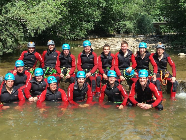 Junggesellenabschied Starzlachklamm Junggesellenabschied in roten Anzügen und blauen Helmen im Wasser, bereit zum Canyoning in der Starzlachklamm